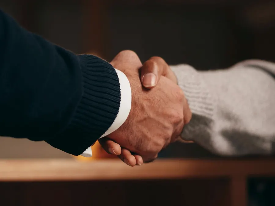 Close-up of a handshake across a desk